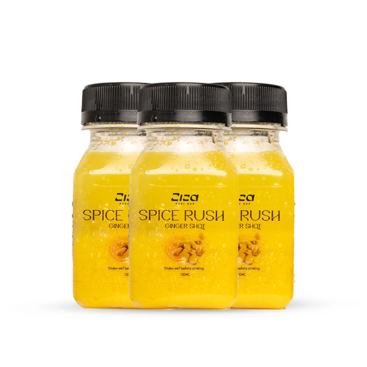 Three 120ml bottles of Spice Rush ginger shot cold pressed natural juice from Ziza fuel bar on a white background.